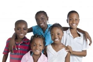 Five happy african kids holding one another, Studio Shot